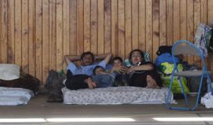 Ромско семейство, настанено в училищен физкултурен салон край Париж, чака да бъде превозено до летище във френската столица