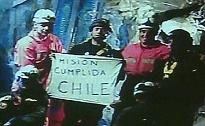  Спасителите, които влязоха в шахтата, с цел да извадят миньорите, демонстрират надпис: 