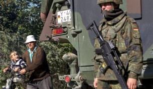 Войник от Кейфор и етнически албанец от Косово с внучето си при село Габра в Северно Косово (снимка от 18 октомври 2011)