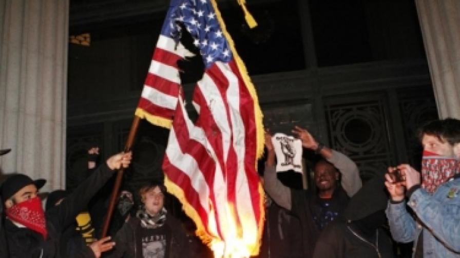 Демонстранти палят американско знаме пред сградата на конгресния център