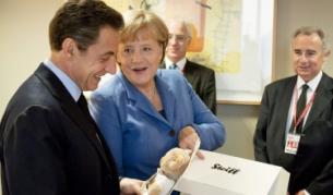 Германският канцлер Ангела Меркел подарява на френския президент Никола Саркози мече по случай раждането на дъщеря му