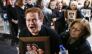 Роднини на жертвите от катастрофата държат техни снимки при протест срещу оправдателната присъда на кипърския съд