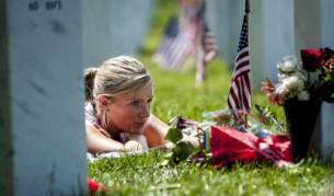 Млада американка е легнала край гроба на брат си във Националното военно гробище в Арлингтън, Вирджиния