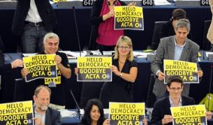 След гласуването евродепутати вдигнаха плакати, на които пише: "Здравей, демокрация, сбогом, ACTA"