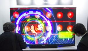 Японски бизнесмени гледат лазерна телевизия в корпорация "Митсобуши" през 2011 г.