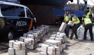 Испански полицаи разтоварват кокаина, заловен на българския кораб