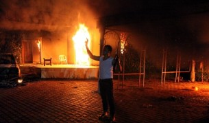 Въоръжен мъж се снима пред горящата сграда на американската мисия в Бенгази