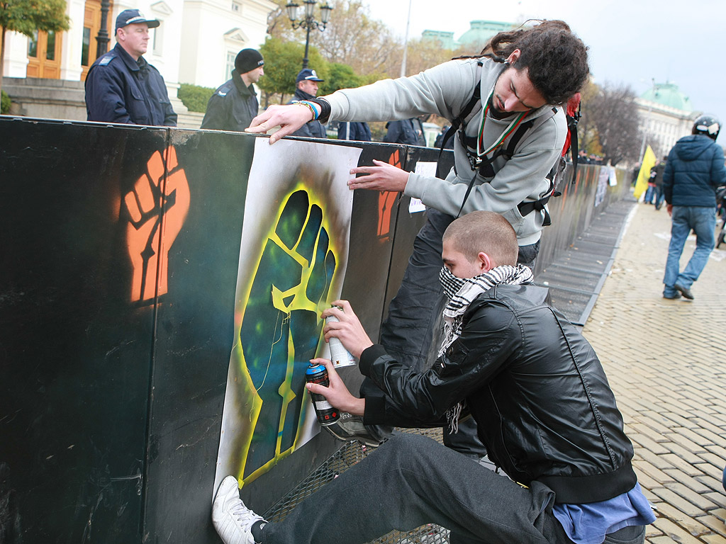 Тази сутрин Парламента отново беше обсаден от протестиращи, които бяха посрещнати от много по-сериозни от досегашните ограждения около сградата. Участниците в протеста бяха пред НС от около 10,30 ч. до към 14 ч., когато приключи работният ден на депутатите, след което се организираха и потеглиха към сградата на МВР