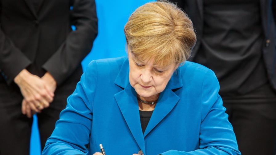 Ангела Меркел, която започва трети мандат като канцлер, подписва коалиционното споразумение