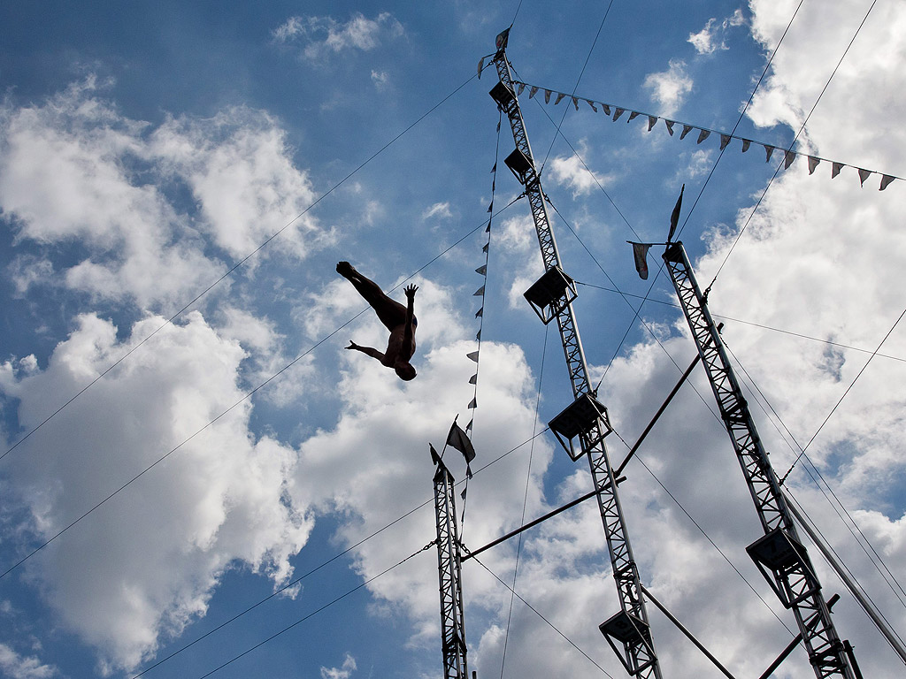 Акробат лети след скока си от кула в басейн в увеселителен парк в Гайзенвинд, Германия, на 13 август.