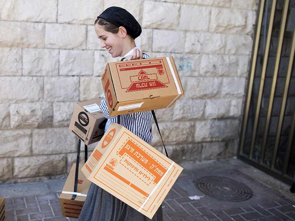 Ортодоксална еврейка носи комплект маски, доставени от командването на въоръжените сили по време на разпределението на газови маски в Ерусалим, Израел, 26 август 2013. Разпределението на газовите маски е в резултат на положението
в Сирия